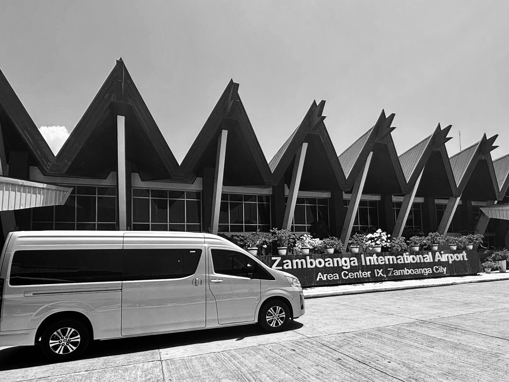 Luxury Toyota Grandia Tourer style van at an airport curb